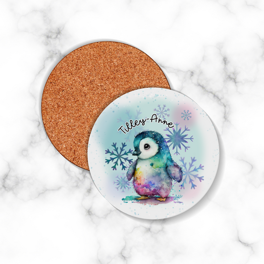 Coaster with a penguin design and cork back on a marble surface